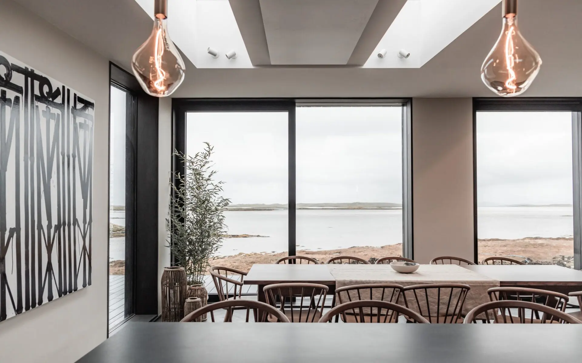 Open Plan Hygge Kitchen With Large Windows And Soft Pendant Lighting Designed For Calm Airy Living